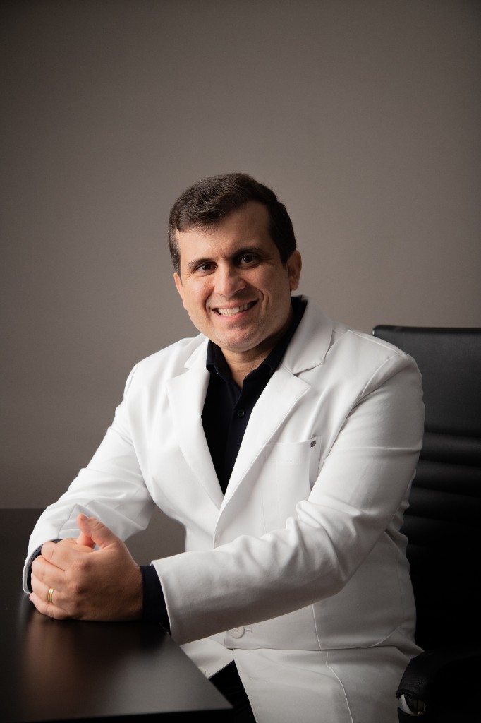 Dr. Rodrigo Siqueira, médico endocrinologista, de jaleco branco, sorrindo